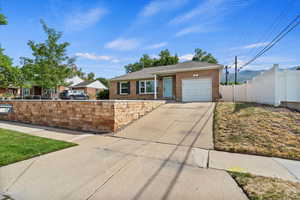 Ranch-style home featuring driveway, brick siding, and an attached garage