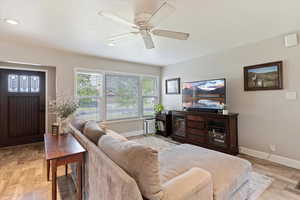 Living area featuring light wood finished floors, ceiling fan, and recessed lighting
