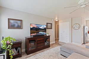 Living room with a ceiling fan and baseboards