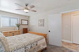 Bedroom featuring a ceiling fan, New carpet, and wood finished floors