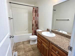 Full bathroom featuring shower / tub combo, vanity, and dark tile patterned floors