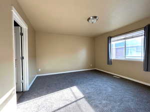 Empty room with carpet and baseboards