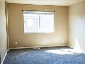 Carpeted empty room with baseboards