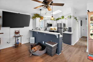 Kitchen with white cabinets, light wood-type flooring, a ceiling fan, open shelves, and lofted ceiling