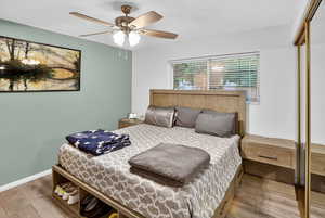 Bedroom featuring a closet, wood finished floors, and ceiling fan