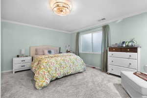 Bedroom featuring ornamental molding and light colored carpet