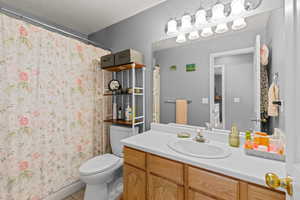 Full bathroom with vanity, a textured ceiling, and light tile patterned flooring
