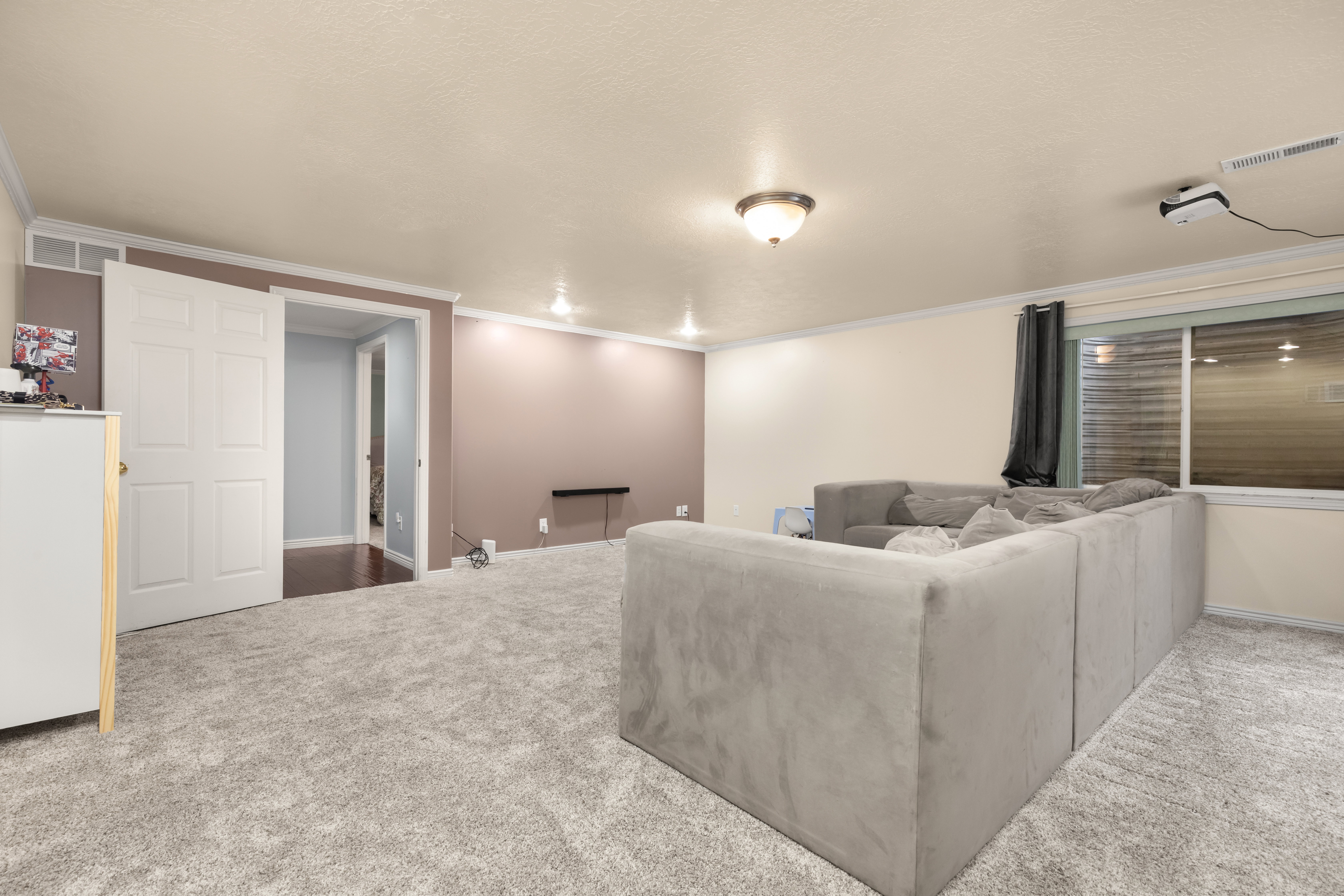 Living area with carpet floors, crown molding, and a textured ceiling
