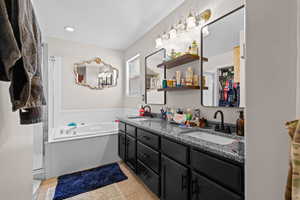 Bathroom featuring double vanity, a bath, and light tile patterned floors