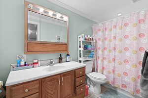 Full bathroom with vanity, crown molding, light tile patterned flooring, and shower / tub combo