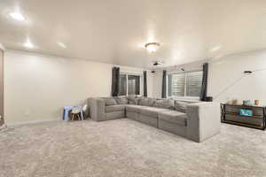 Carpeted living room featuring a textured ceiling and ornamental molding