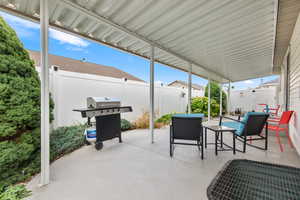 Fenced backyard featuring a patio and a grill