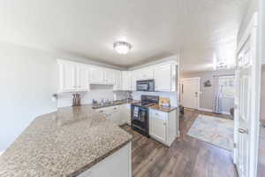 White cabinetry with crown molding, beautiful backsplash and updated cabinet hardware.