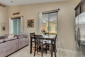 Dining space with healthy amount of natural light, vaulted ceiling, and light wood-type flooring