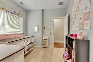 Bedroom with light wood-style flooring and baseboards