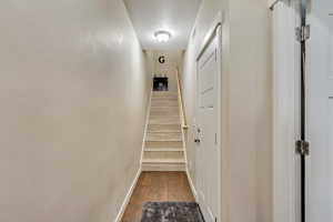 Corridor with dark wood-style flooring and stairs