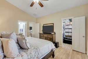 Main bedroom with a spacious closet, light wood-style flooring, a ceiling fan, and vaulted ceiling