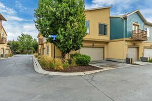 View of side facade featuring stucco siding, concrete driveway, and an attached garage