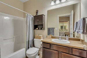 Main bathroom featuring shower / bath combo with shower curtain, vanity, and ensuite bathroom
