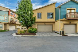 View of property with stucco siding, concrete driveway, a garage