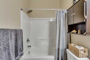 Bathroom featuring shower with curtain and toilet