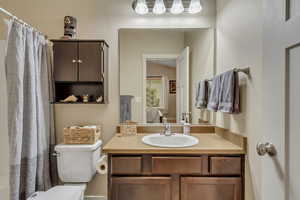 Main bathroom with vanity and curtained shower