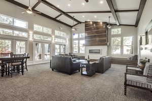 Living room with a fireplace, beam ceiling, carpet flooring, high vaulted ceiling, and recessed lighting