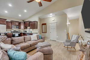 Living room featuring recessed lighting, light wood-style flooring, lofted ceiling, and ceiling fan