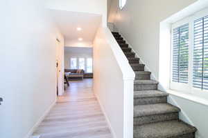 Stairway featuring wood finished floors and recessed lighting