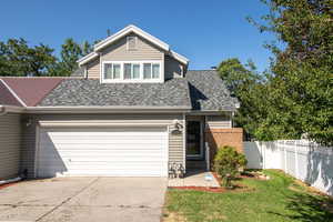 Traditional-style home with driveway, roof with shingles, and brick siding