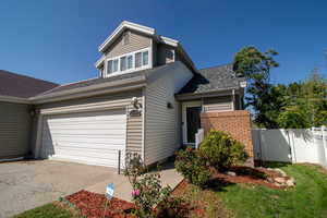 View of front of house featuring concrete driveway, a shingled roof, and an attached garage