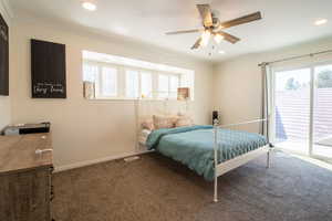 Bedroom featuring multiple windows, carpet floors, ornamental molding, access to outside, and a ceiling fan
