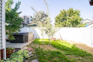 Fenced backyard with a hot tub