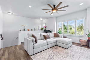 Living area featuring dark wood-style flooring, a ceiling fan, and recessed lighting