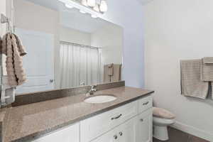 Full bathroom with vanity and a shower with shower curtain