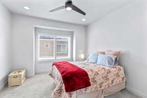 Carpeted bedroom featuring ceiling fan and recessed lighting