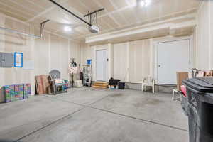 Garage featuring electric panel and a garage door opener