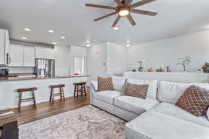 Living area with dark wood-style floors, recessed lighting, and a ceiling fan