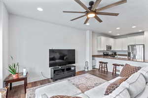 Living room featuring recessed lighting, dark wood finished floors, and ceiling fan