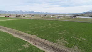 Aerial view of sparsely populated area featuring a mountainous background and extensive farmland