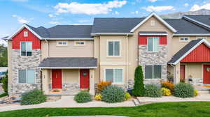 Craftsman-style home featuring stone siding, covered porch, and roof with shingles