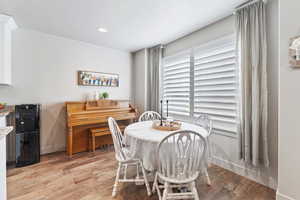 Dining area featuring light wood-style flooring, a textured ceiling, and recessed lighting