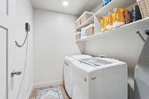 Laundry room featuring light wood finished floors and separate washer and dryer