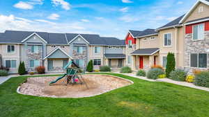 Community play area with a residential view, a lawn, and a porch