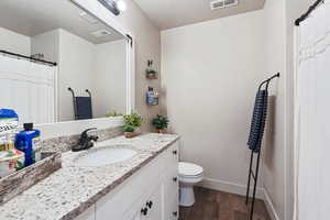 Bathroom featuring dark wood finished floors, vanity, and a textured ceiling