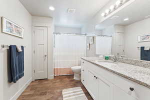 Bathroom with vanity, a textured ceiling, dark wood-style floors, recessed lighting, and a shower with shower curtain