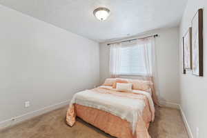 Bedroom with carpet flooring and a textured ceiling