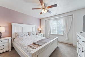 Bedroom featuring dark carpet, a textured ceiling, and ceiling fan
