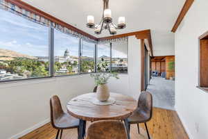Dining room with a chandelier, hardwood / wood-style flooring, a textured ceiling, and a mountain view
