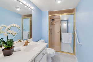 Full bath featuring vanity, a shower stall, and light tile patterned flooring